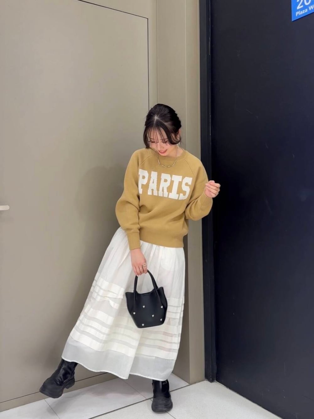 ベージュ系のニット/セーター、ホワイト系のスカート、ブラック系のショルダーバッグを着用したレディースの冬コーディネートの1枚目の写真