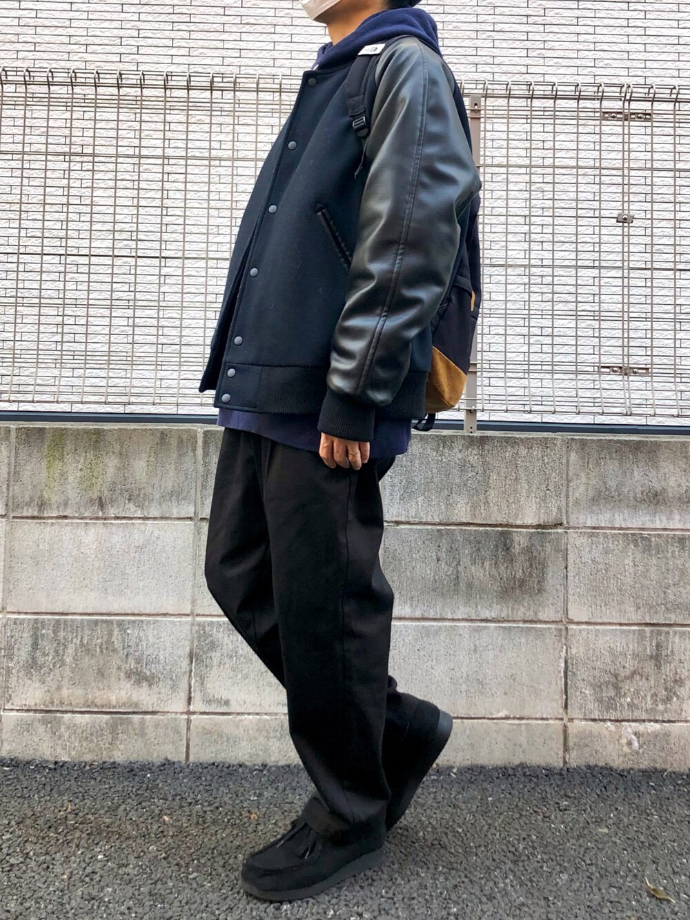 ブラック系のバックパック/リュック、グレー系のデニムパンツ、ブラック系のモカシン/デッキシューズを着用したメンズの冬コーディネートの1枚目の写真