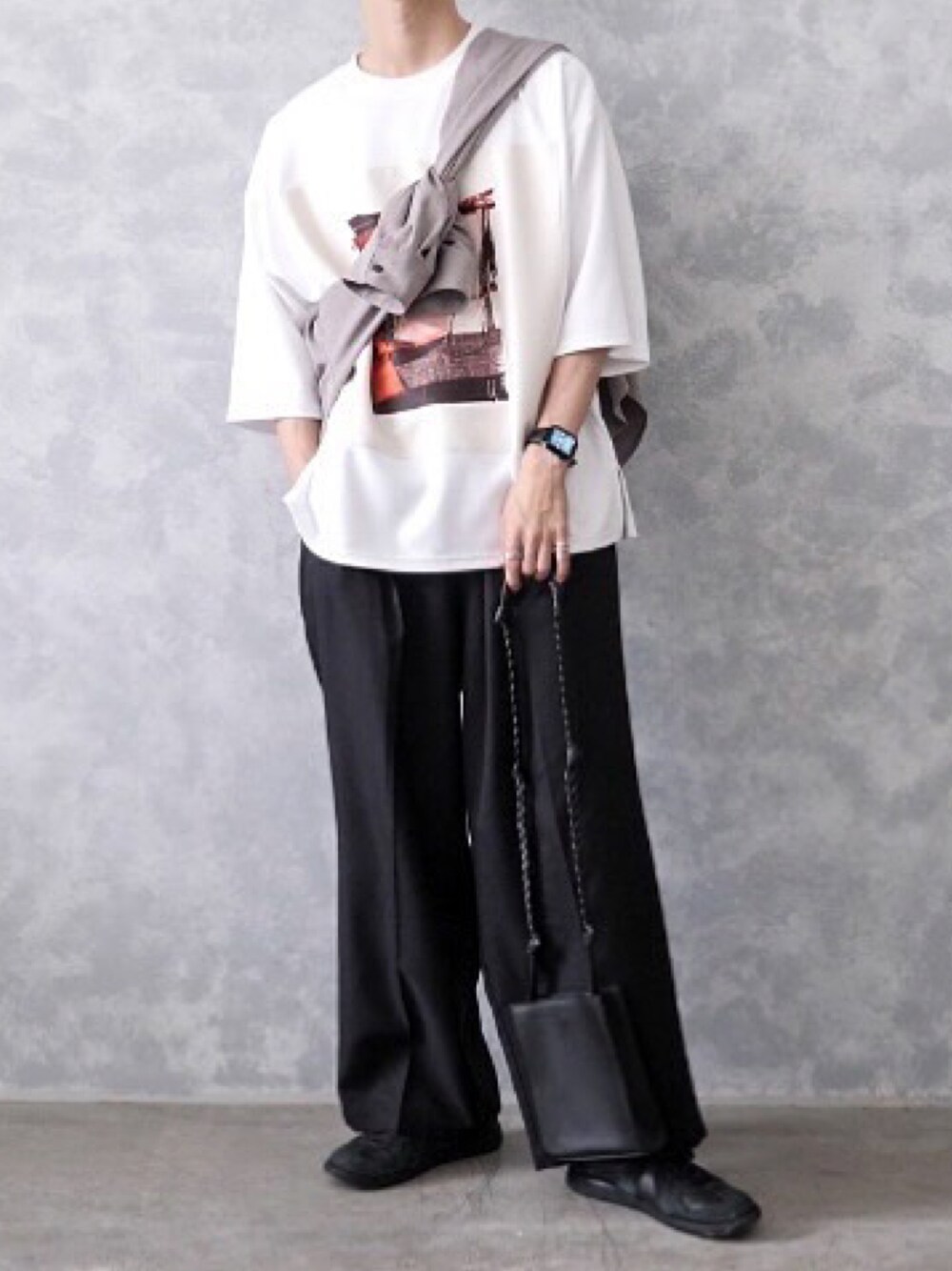 ブラック系のスラックス、ホワイト系のTシャツ/カットソー、ブラック系のスニーカーを着用したメンズの春コーディネートの1枚目の写真