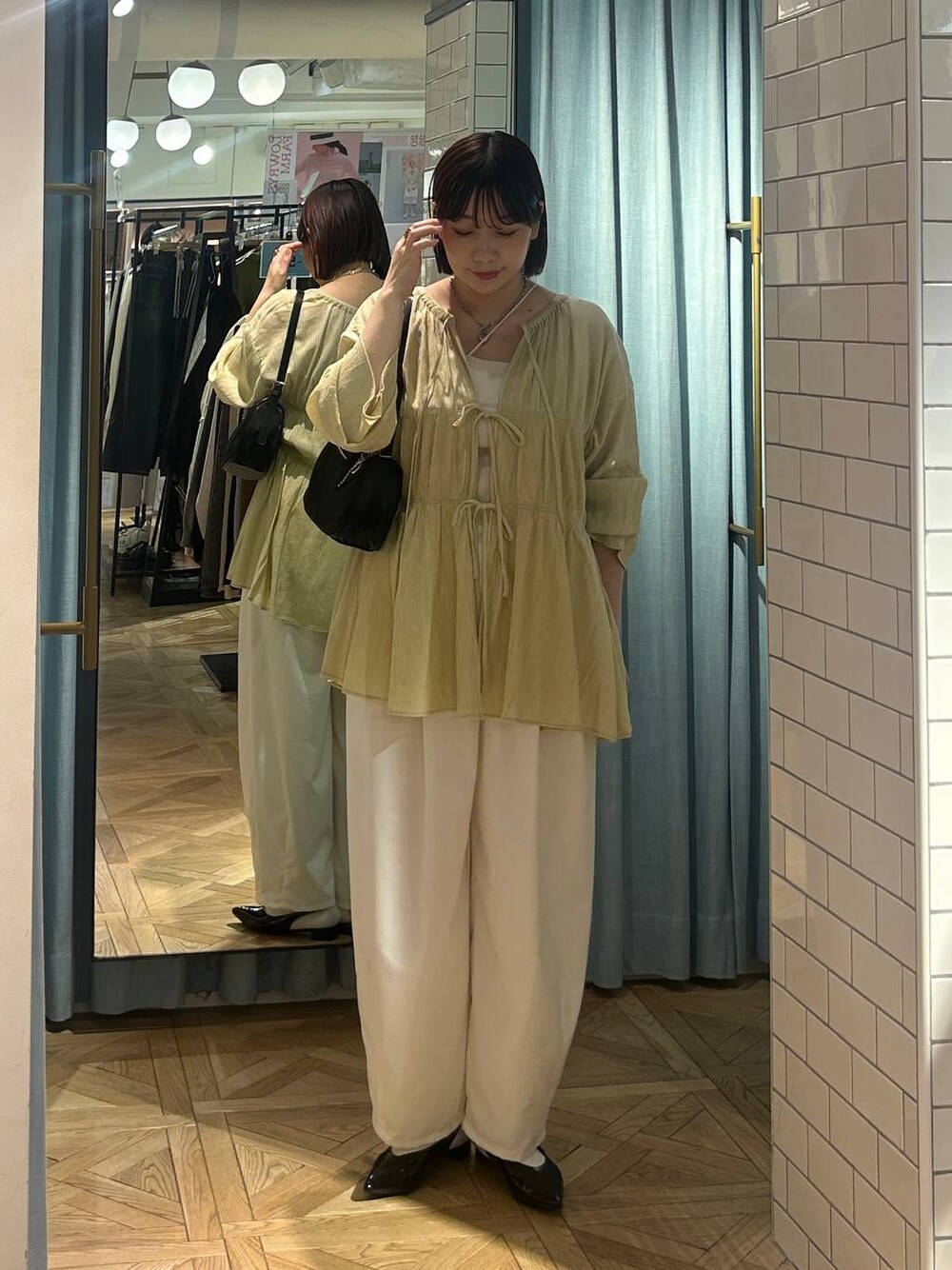 イエロー系のシャツ/ブラウス、ブラック系のトートバッグ、ブラック系のパンプスを着用したレディースの春コーディネートの1枚目の写真