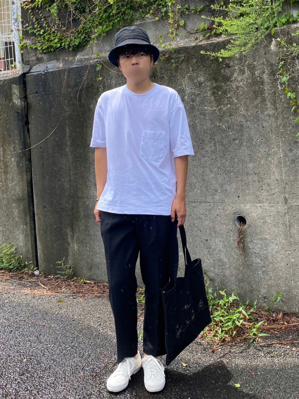 ホワイト系のTシャツ/カットソー、ブラック系のスラックス、ブラック系のトートバッグを着用したメンズの夏コーディネートの1枚目の写真