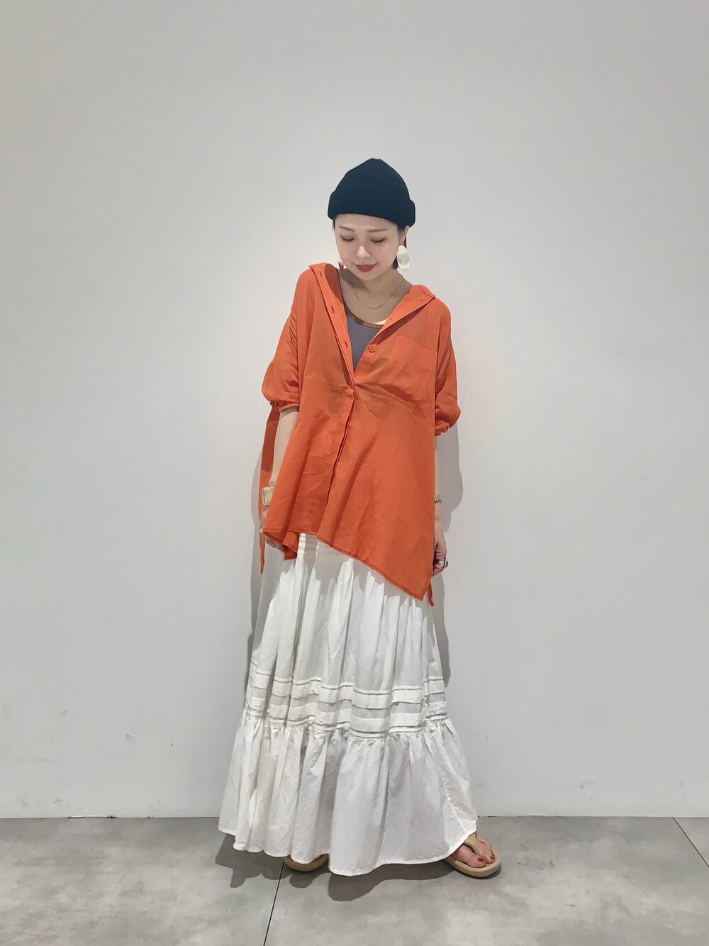 オレンジ系のシャツ/ブラウス、ピンク系のタンクトップ、ホワイト系のスカートを着用したレディースの夏コーディネートの1枚目の写真