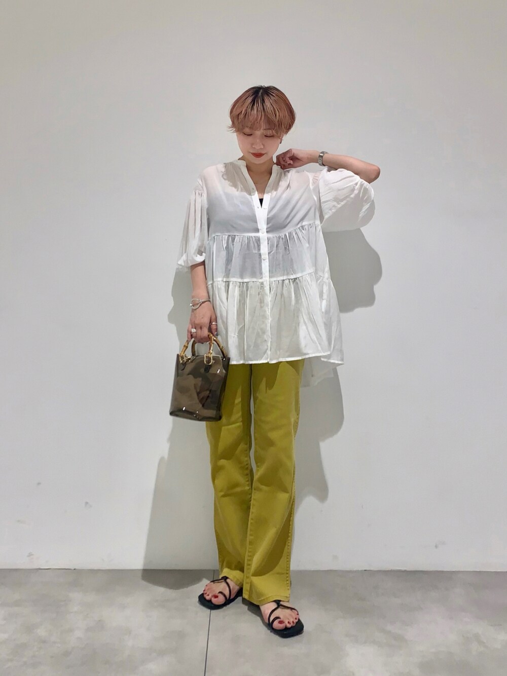 イエロー系のシャツ/ブラウス、イエロー系のデニムパンツ、ブラック系のショルダーバッグを着用したレディースの夏コーディネートの1枚目の写真