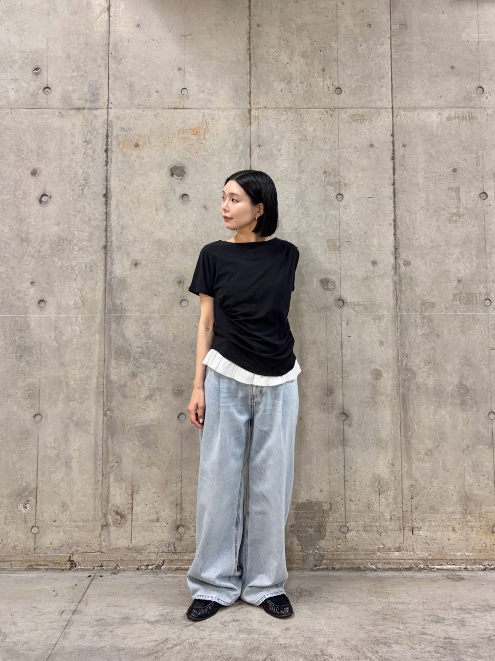 ブラック系のTシャツ/カットソー、ブルー系のデニムパンツを着用したレディースの春コーディネートの1枚目の写真