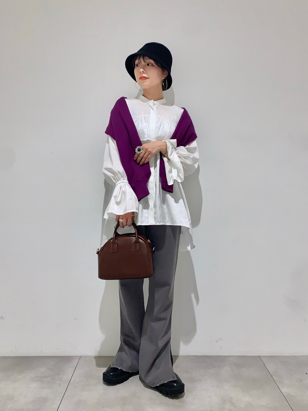 パープル系のカーディガン/ボレロ、ベージュ系のショルダーバッグ、ホワイト系のシャツ/ブラウスを着用したレディースの秋コーディネートの1枚目の写真