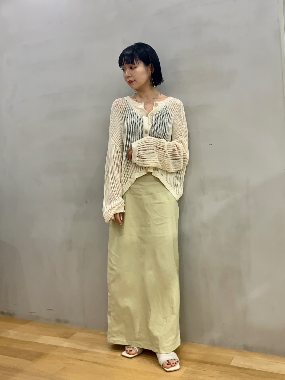 ホワイト系のサンダル、ホワイト系のカーディガン/ボレロ、イエロー系のスカートを着用したレディースの夏コーディネートの1枚目の写真
