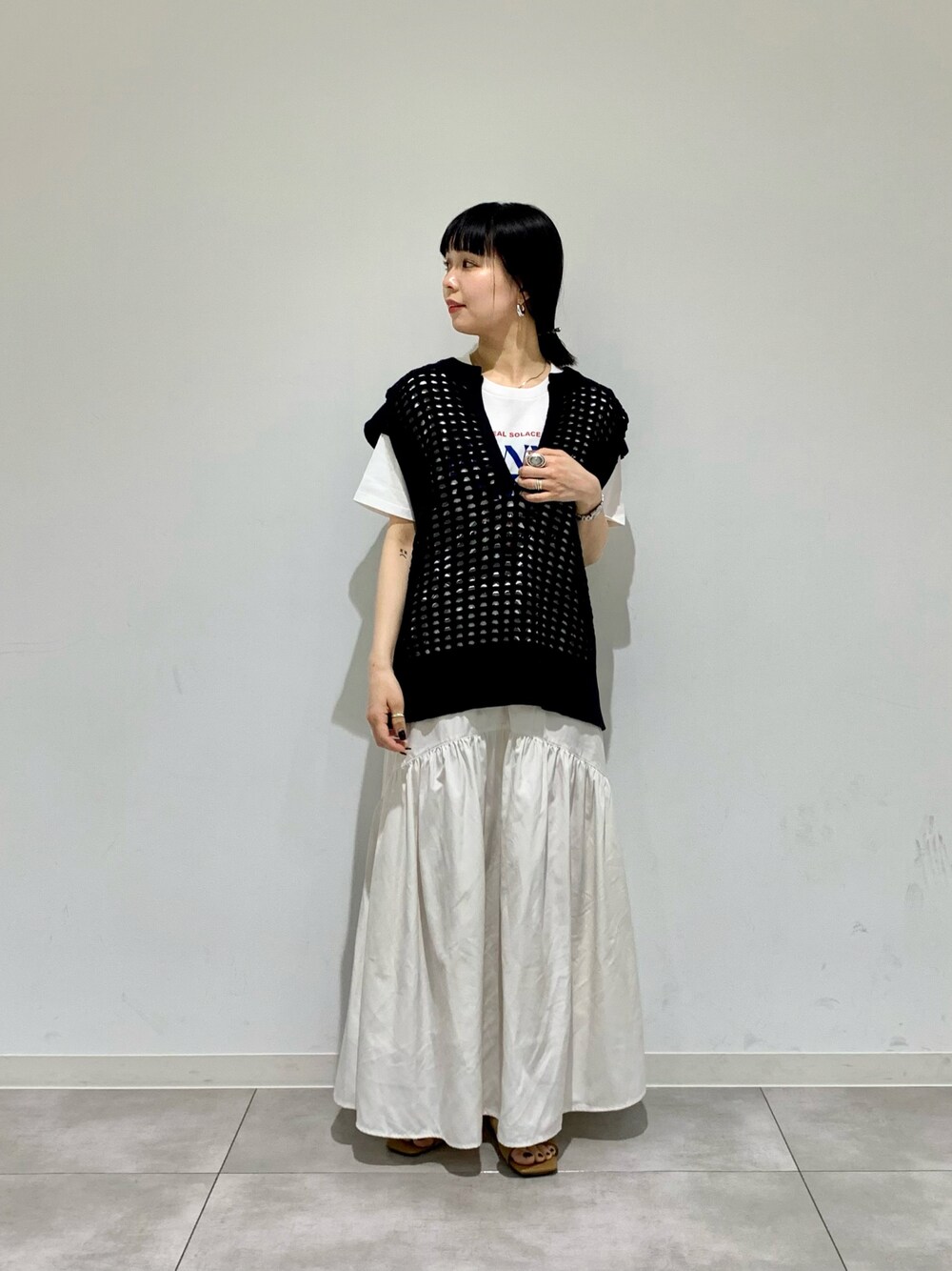 ホワイト系のサンダル、その他のTシャツ/カットソー、ブラック系のベストを着用したレディースの春コーディネートの1枚目の写真