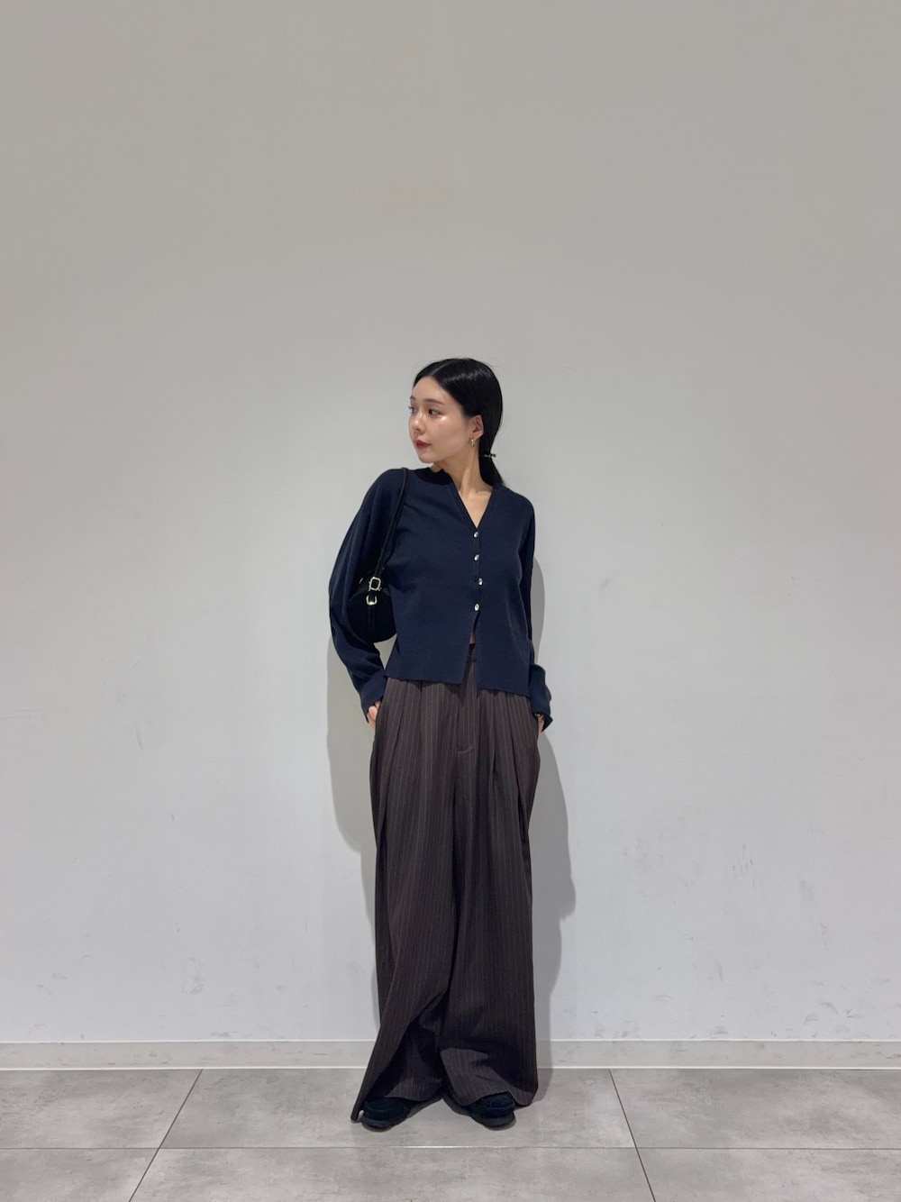 ブルー系のカーディガン/ボレロ、ブラウン系のその他パンツ、ブラック系のブーツを着用したレディースの秋コーディネートの1枚目の写真