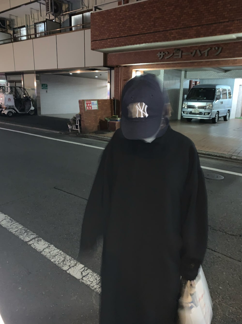 ブラック系のモッズコート、ブルー系のキャップを着用したレディースの春コーディネートの1枚目の写真