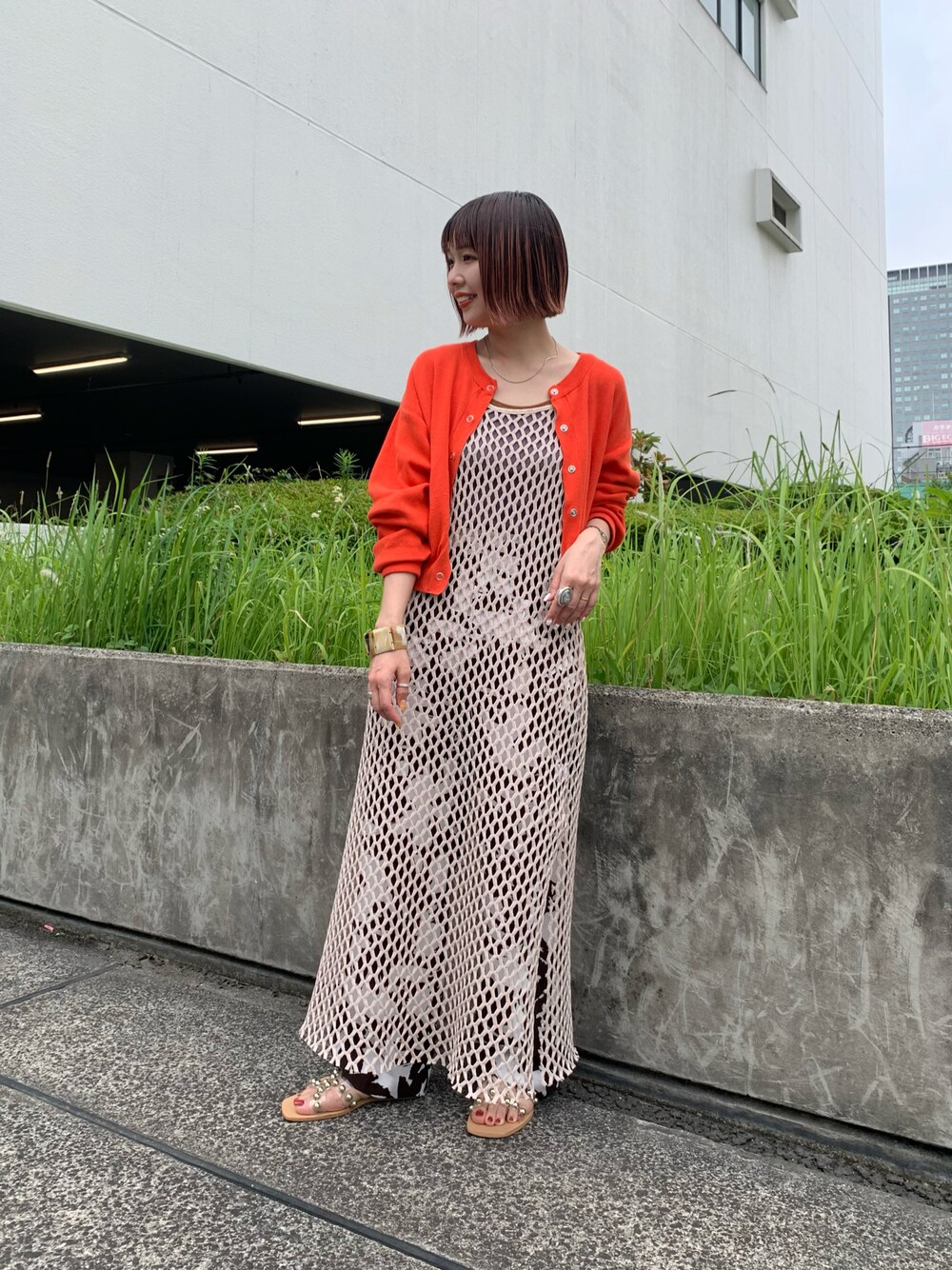 オレンジ系のカーディガン/ボレロ、ブルー系のタンクトップ、ブラウン系のその他パンツを着用したレディースの夏コーディネートの1枚目の写真