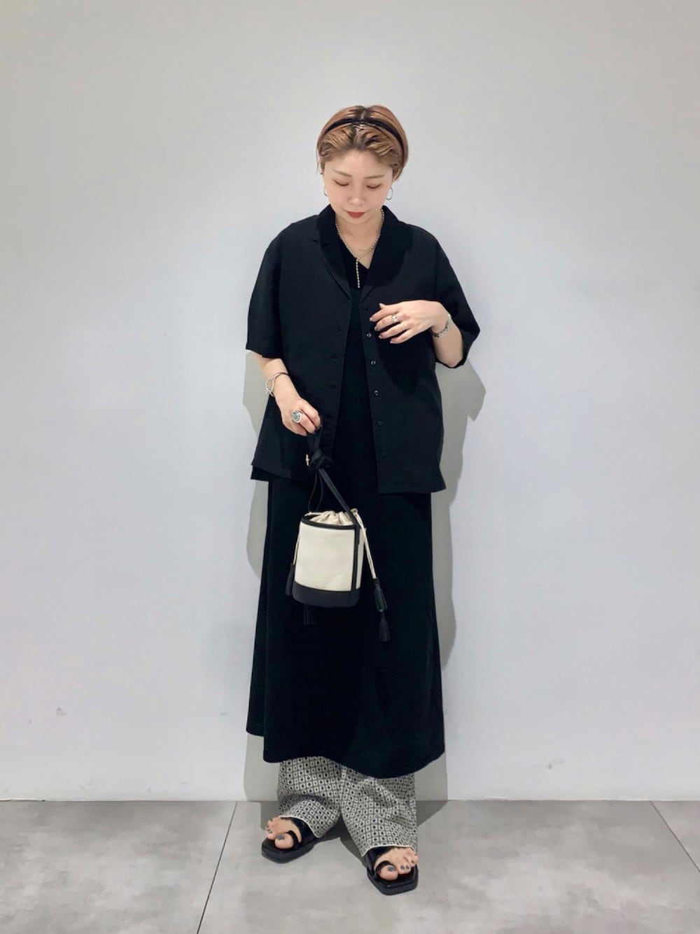 ブラック系のシャツ/ブラウス、ブラック系のその他パンツ、ブラウン系のショルダーバッグを着用したレディースの夏コーディネートの1枚目の写真