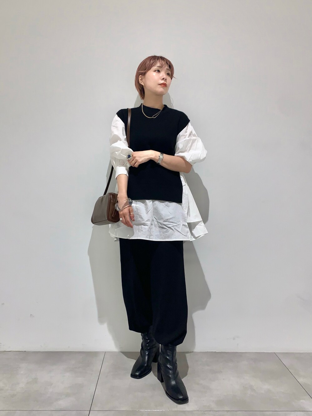 オレンジ系のその他パンツ、ブラック系のニット/セーター、その他のショルダーバッグを着用したレディースの秋コーディネートの1枚目の写真