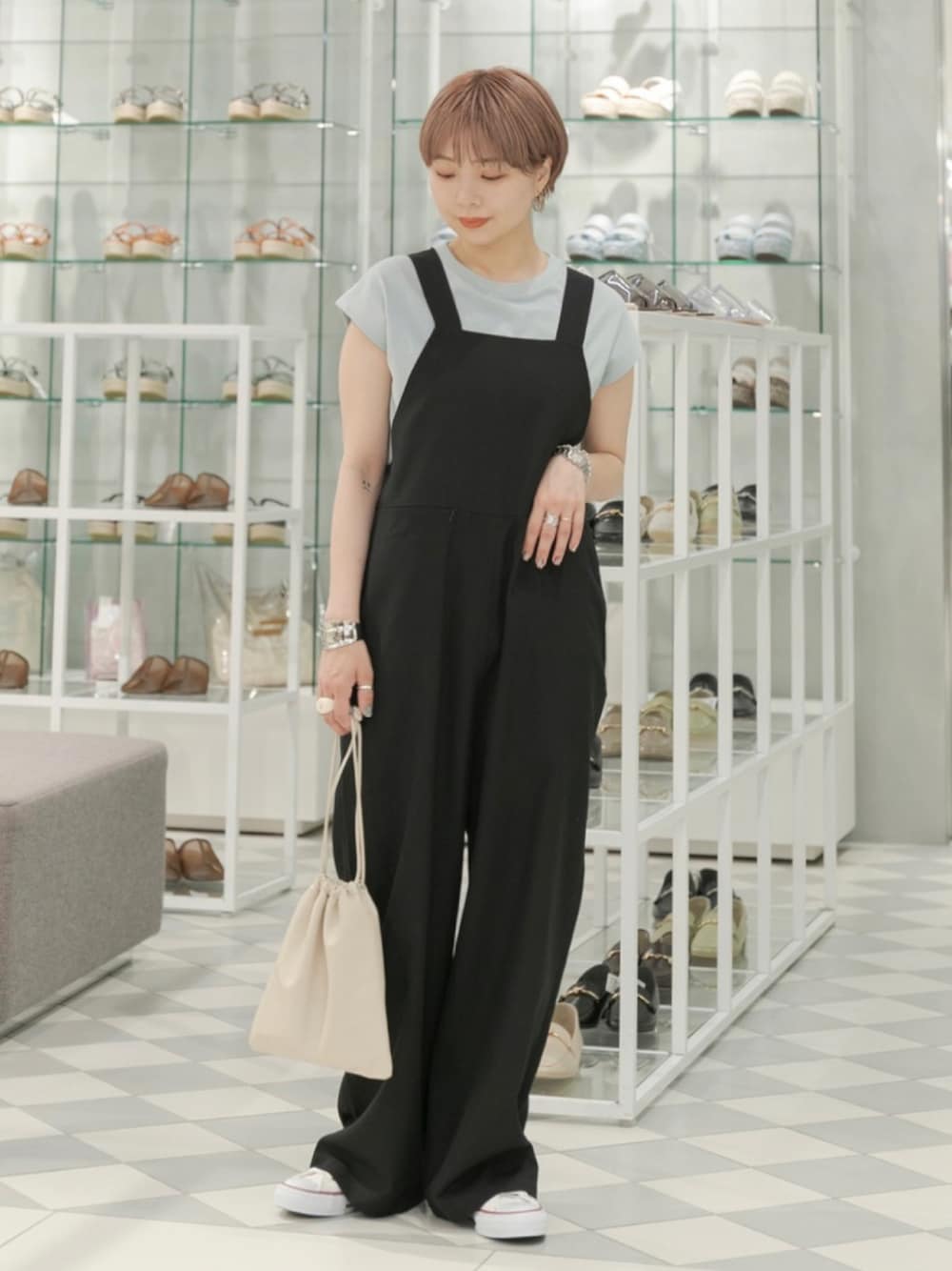 ブラック系のサロペット/オーバーオール、グリーン系のTシャツ/カットソー、ホワイト系のスニーカーを着用したレディースの夏コーディネートの1枚目の写真