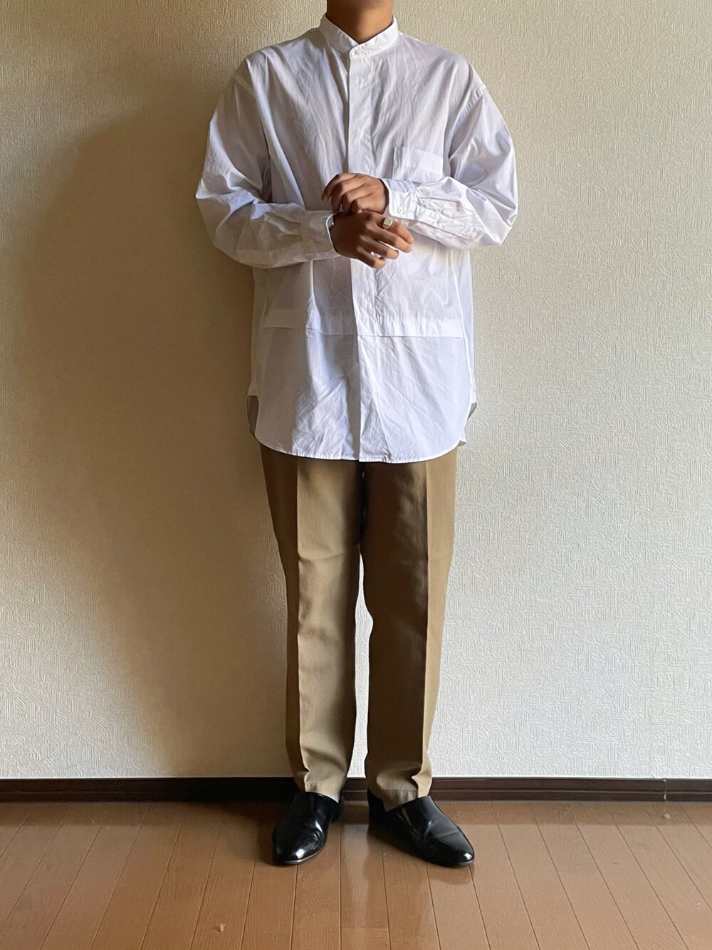 ホワイト系のシャツ/ブラウス、ベージュ系のチノパンツ、ブラック系のドレスシューズを着用したメンズの秋コーディネートの1枚目の写真