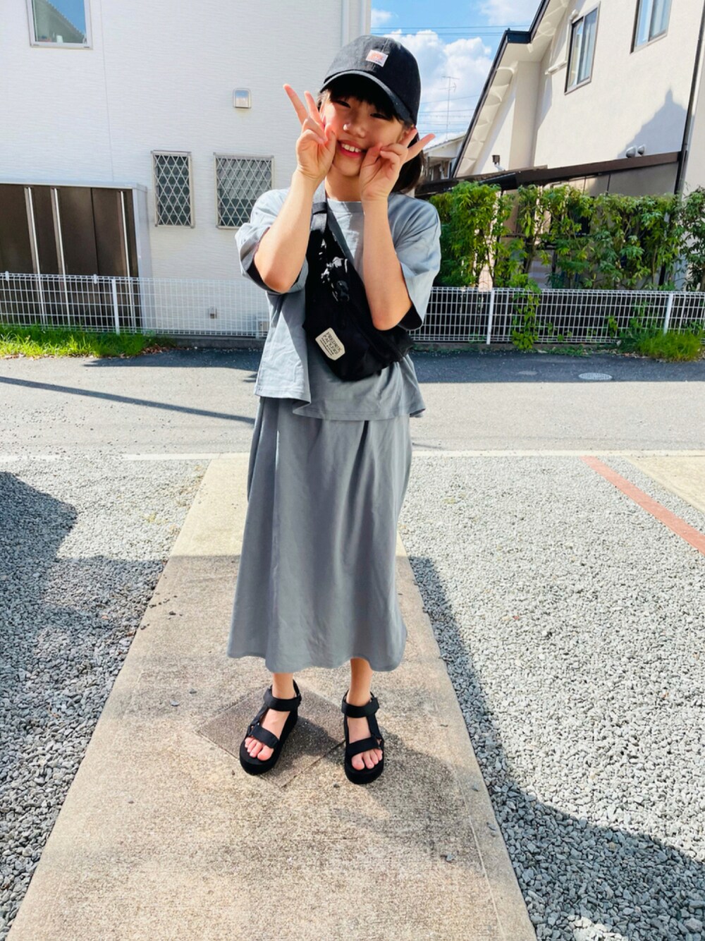 グリーン系のワンピース、ブラック系のサンダル、ブラック系のボディバッグ/ウエストポーチを着用したキッズの夏コーディネートの1枚目の写真