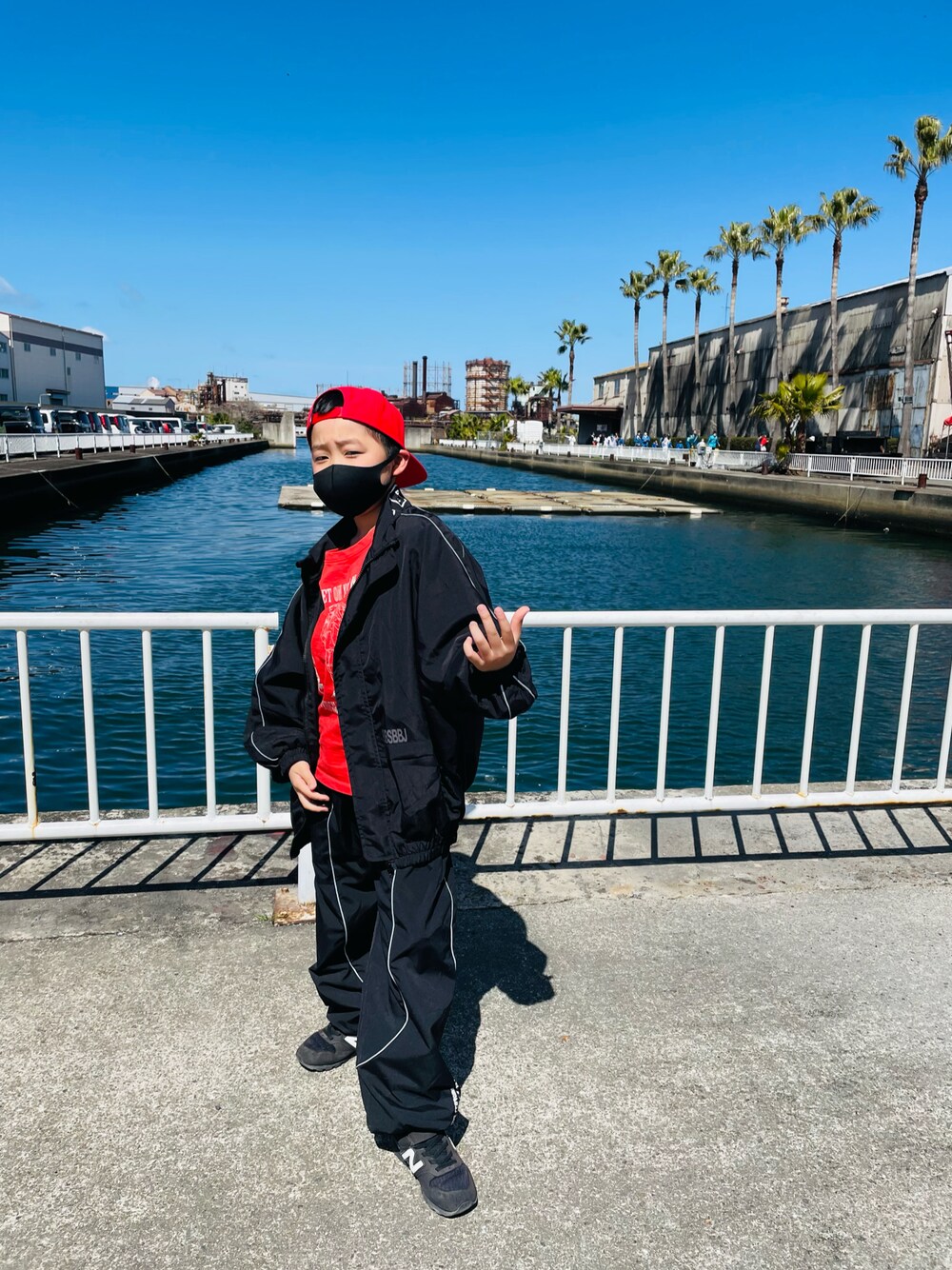 レッド系のTシャツ/カットソー、ブラック系のスニーカー、レッド系のキャップを着用したキッズの春コーディネートの1枚目の写真