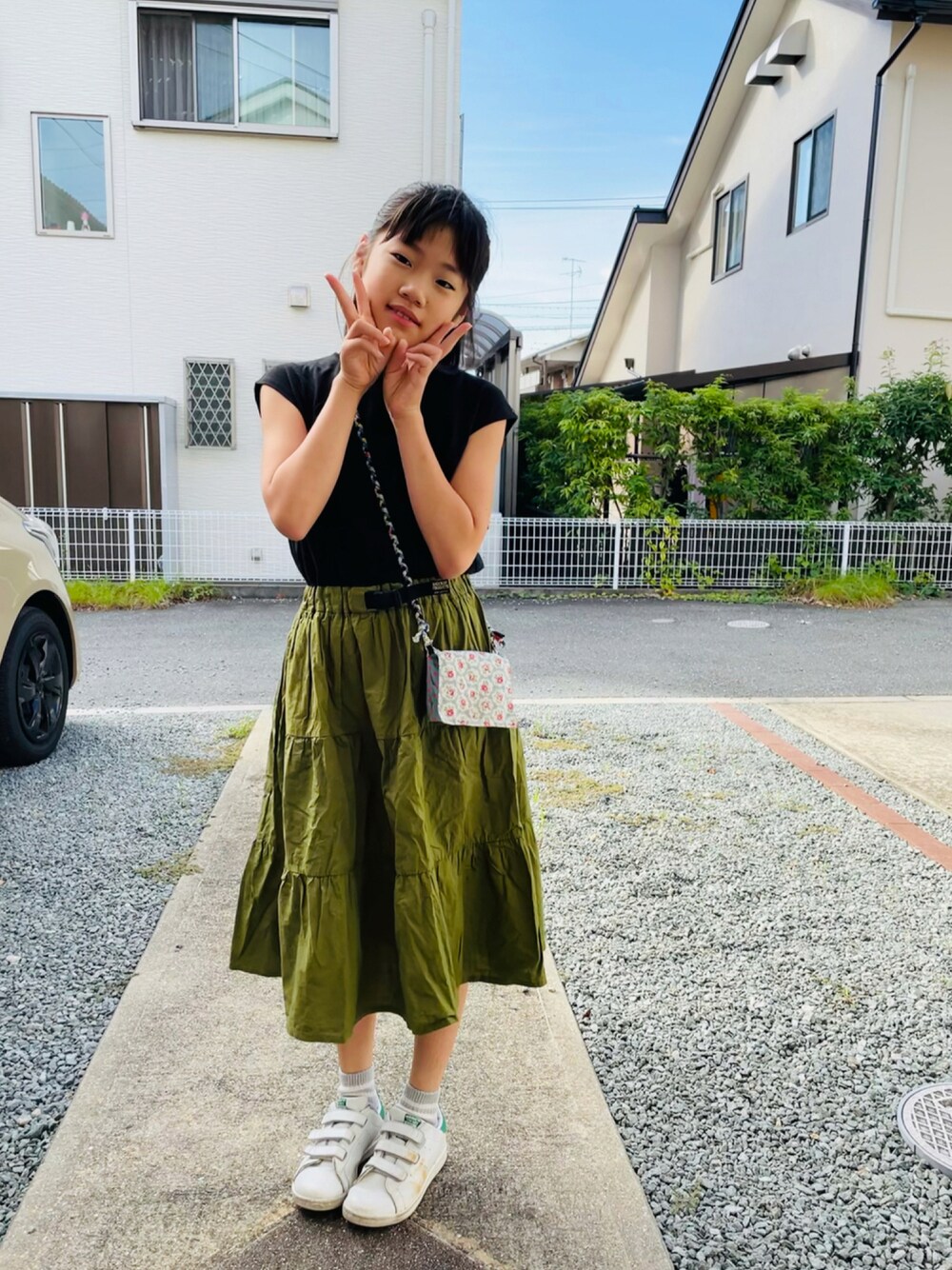 ブラック系のワンピース、ホワイト系のスニーカー、その他のTシャツ/カットソーを着用したキッズの秋コーディネートの1枚目の写真