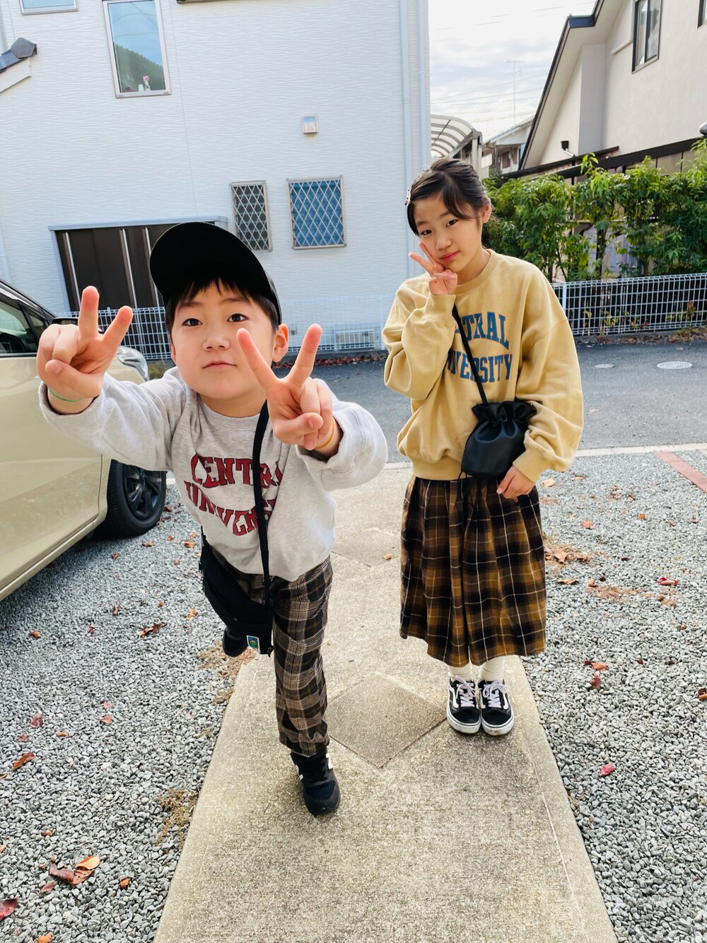 ブラック系のハンドバッグ、ベージュ系のスウェット、グレー系のスウェットを着用したキッズの秋コーディネートの1枚目の写真