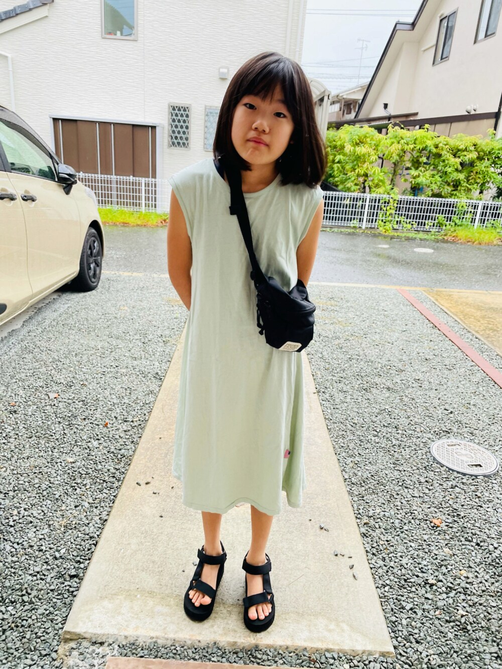 グリーン系のワンピース、ブラック系のサンダル、ブラック系のボディバッグ/ウエストポーチを着用したキッズの秋コーディネートの1枚目の写真