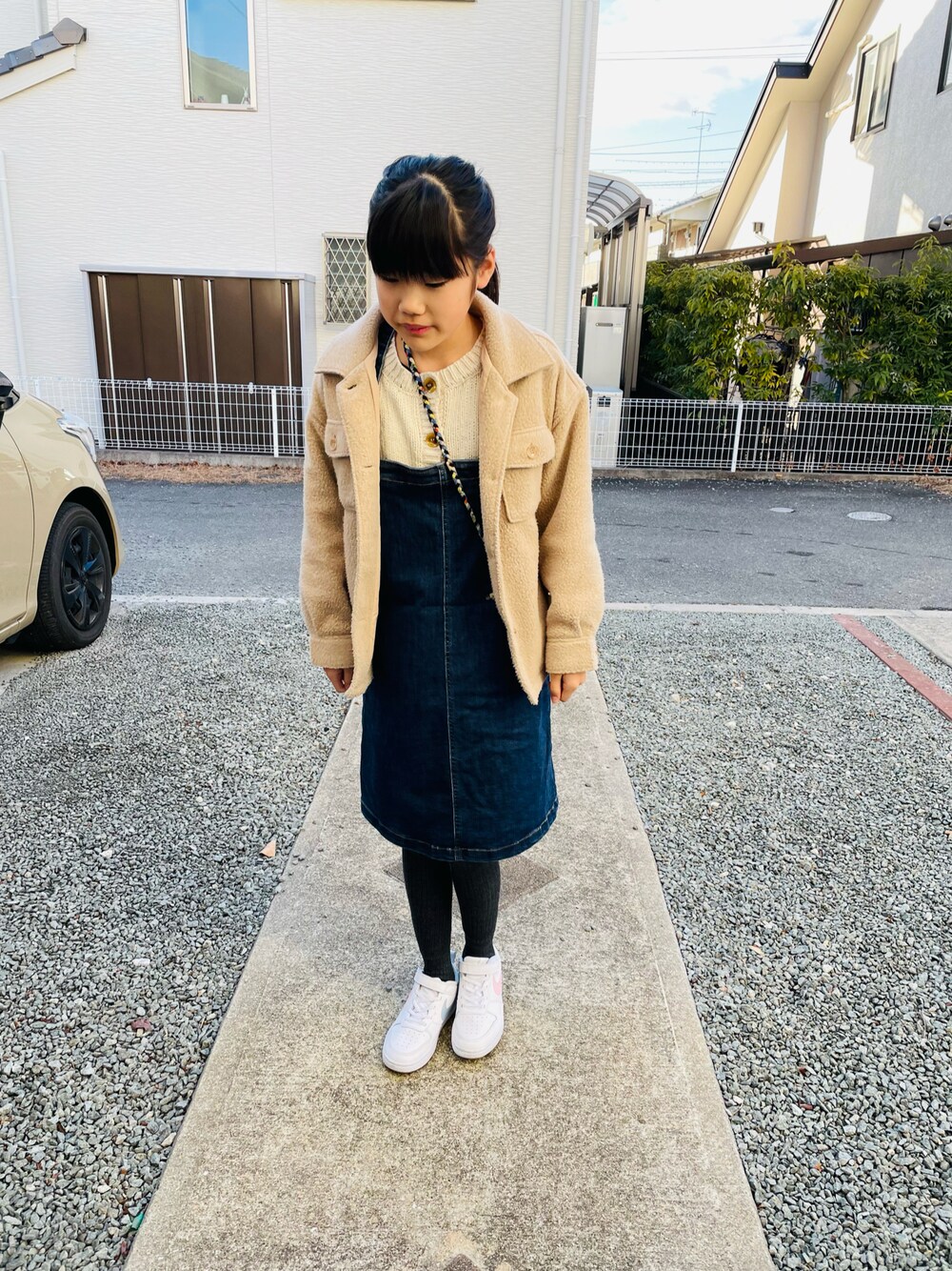 ベージュ系のその他アウター、ブルー系のスカート、ホワイト系のスニーカーを着用したキッズの春コーディネートの1枚目の写真