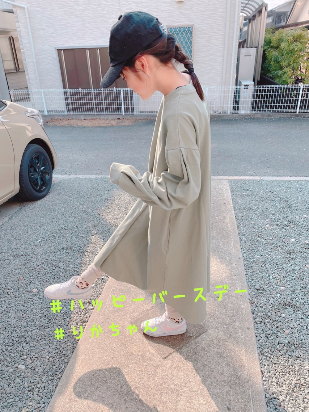 グリーン系のワンピース、ホワイト系のスニーカー、ブラック系のキャップを着用したキッズの春コーディネートの1枚目の写真
