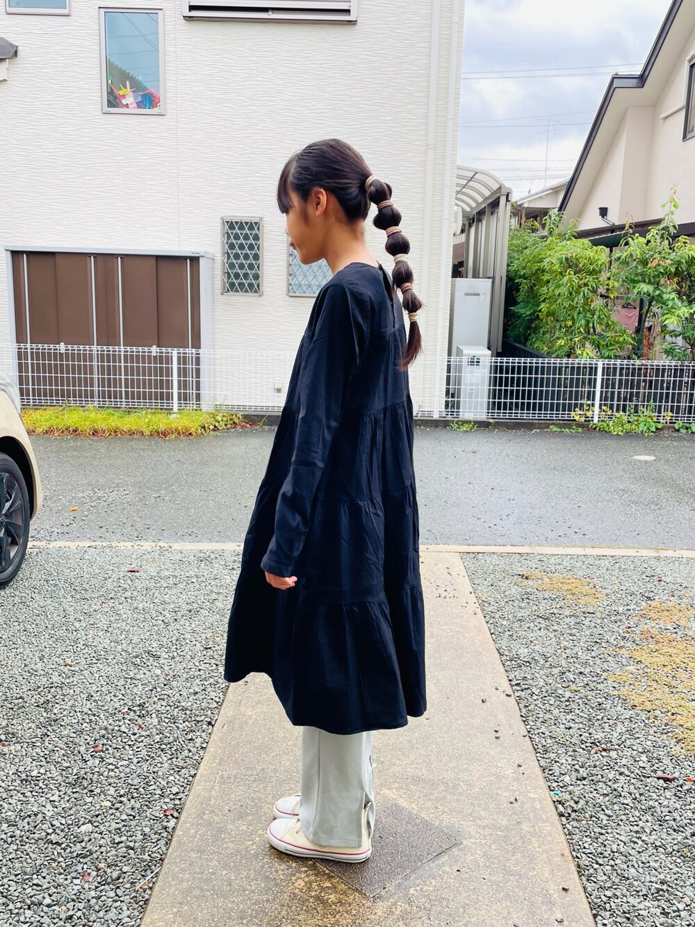 ブラック系のワンピース、グリーン系のその他パンツ、ホワイト系のスニーカーを着用したキッズの秋コーディネートの1枚目の写真