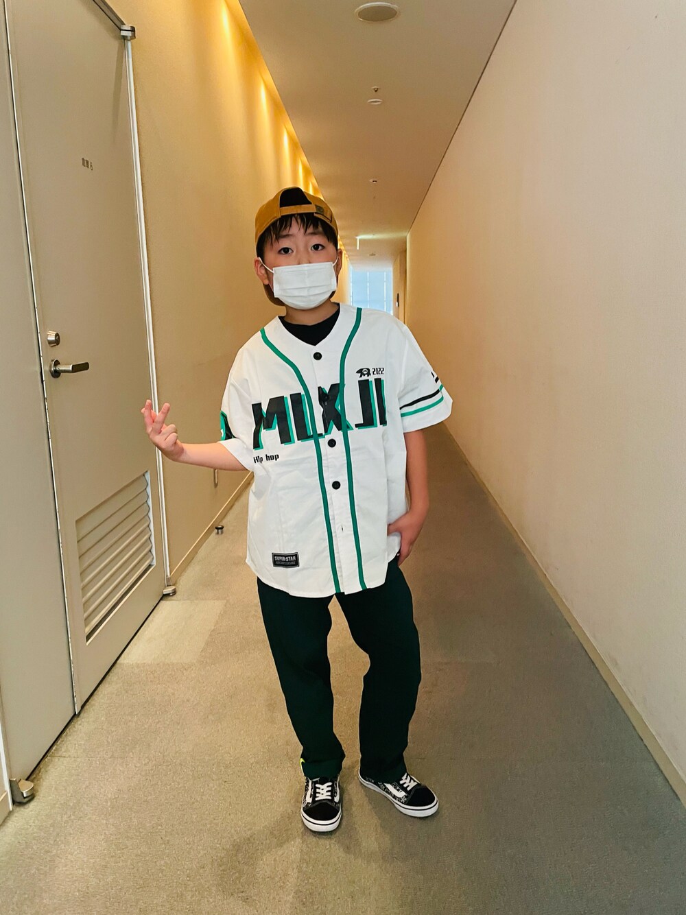 グリーン系のその他パンツ、ブラック系のスニーカー、オレンジ系のキャップを着用したキッズの夏コーディネートの1枚目の写真