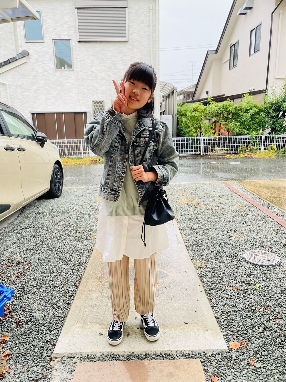 ブルー系のデニムジャケット、ブラック系のハンドバッグ、ベージュ系のその他パンツを着用したキッズの秋コーディネートの1枚目の写真