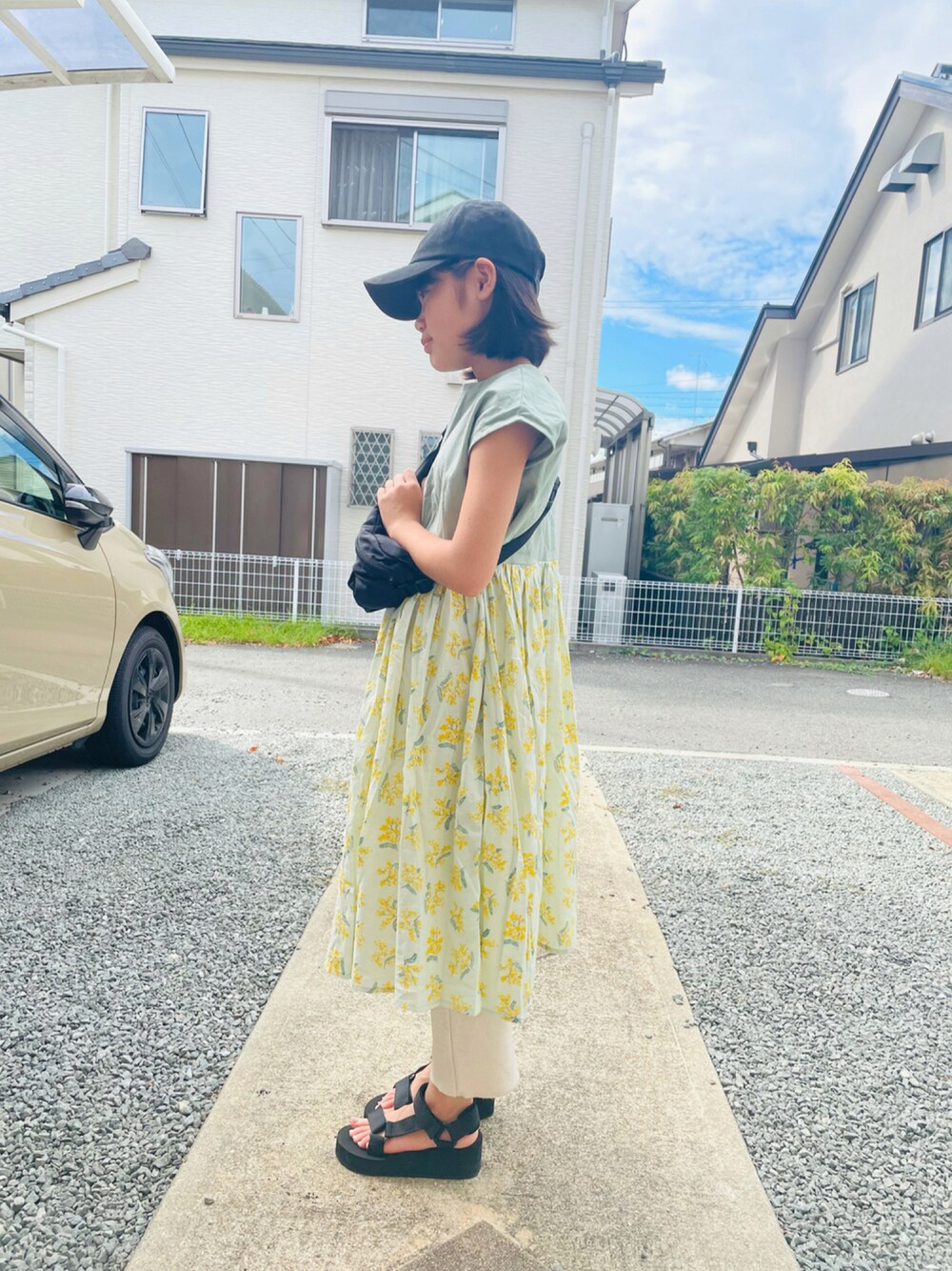 グリーン系のワンピース、ブラック系のボディバッグ/ウエストポーチ、ブラック系のサンダルを着用したキッズの秋コーディネートの1枚目の写真