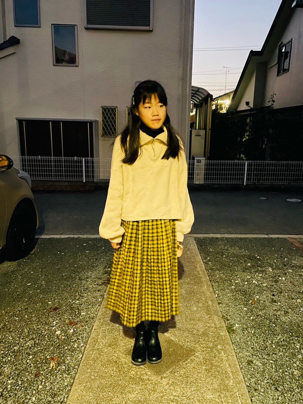 ホワイト系のニット/セーター、イエロー系のスカート、ブラック系のブーツを着用したキッズの冬コーディネートの1枚目の写真