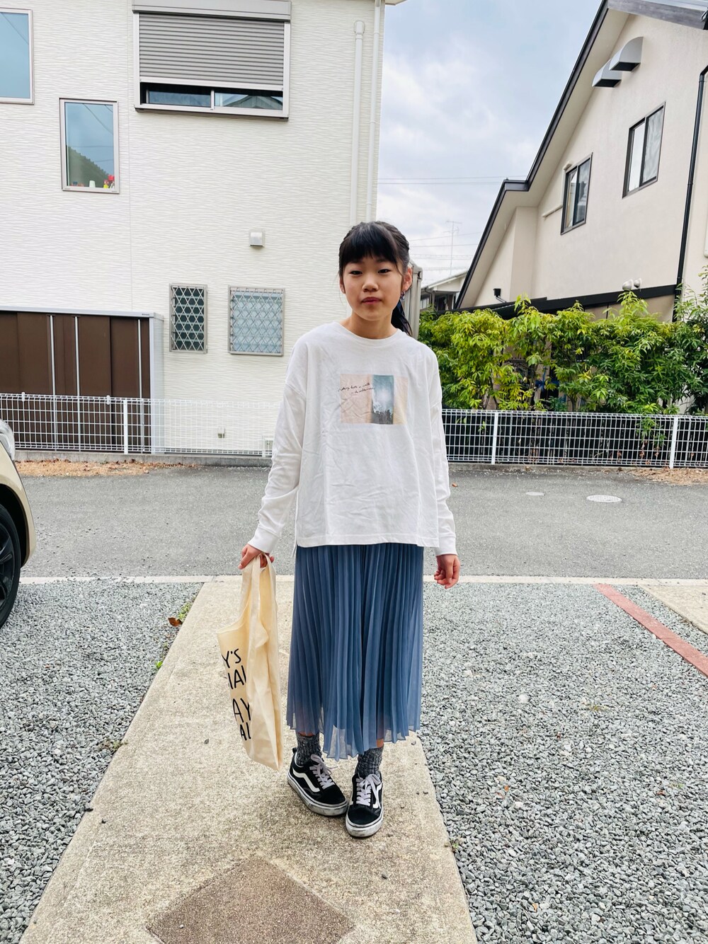 ホワイト系のTシャツ/カットソー、ブルー系のスカート、ホワイト系のエコバッグ/サブバッグを着用したキッズの春コーディネートの1枚目の写真