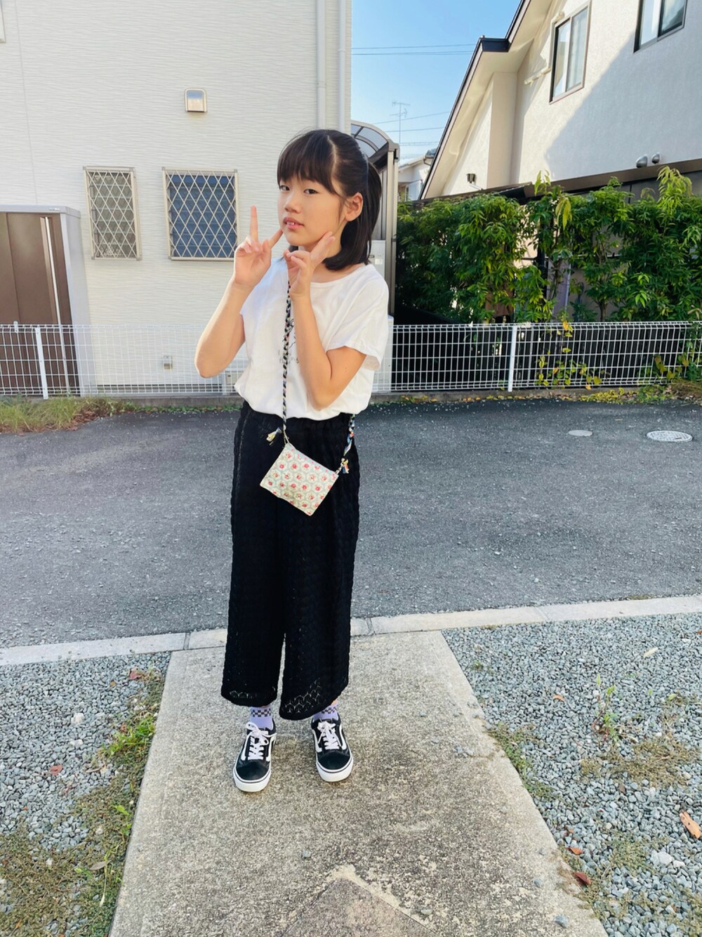 ホワイト系のTシャツ/カットソー、ブラック系のスニーカーを着用したキッズの秋コーディネートの1枚目の写真