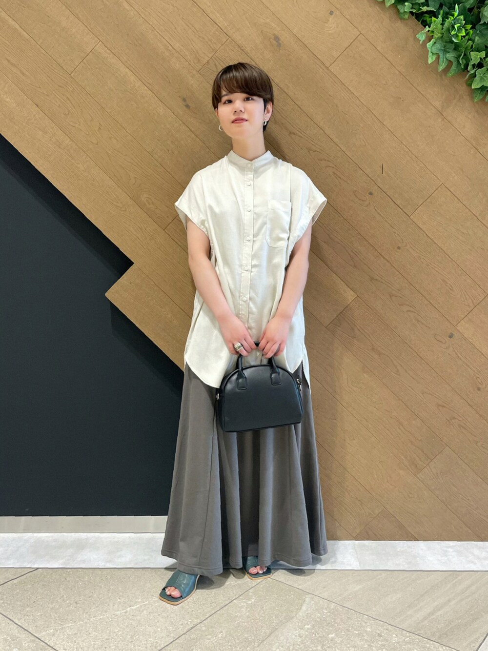 ベージュ系のシャツ/ブラウス、ブラック系のショルダーバッグ、グリーン系のサンダルを着用したレディースの夏コーディネートの1枚目の写真