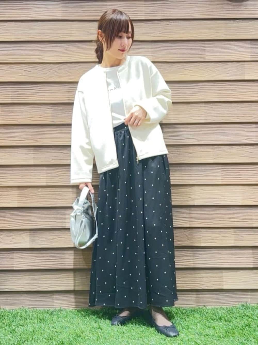 ホワイト系のブルゾン、ホワイト系のTシャツ/カットソー、ブラック系のスカートを着用したレディースの春コーディネートの1枚目の写真