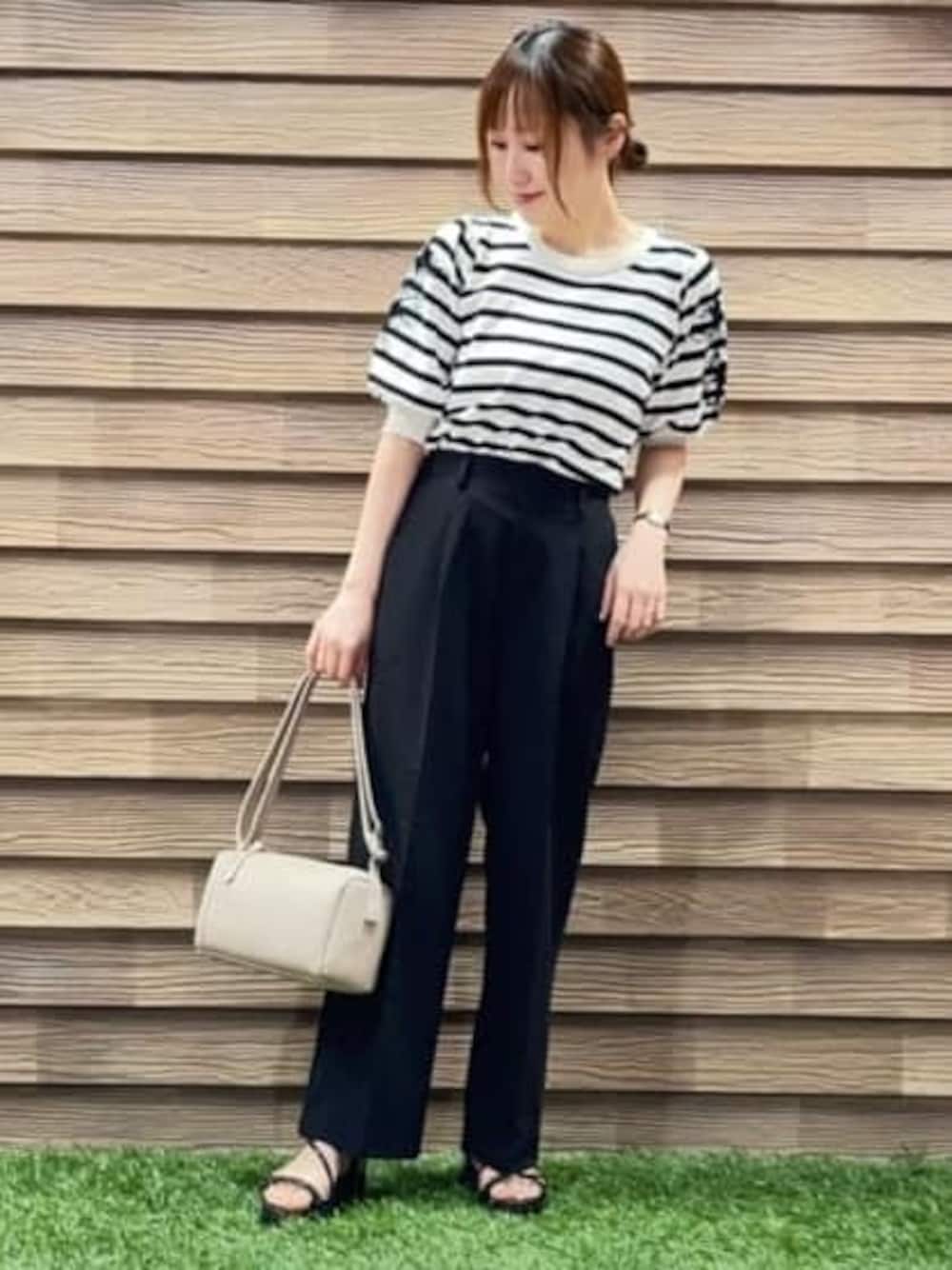ホワイト系のニット/セーター、ブラック系のその他パンツ、ベージュ系のショルダーバッグを着用したレディースの春コーディネートの1枚目の写真
