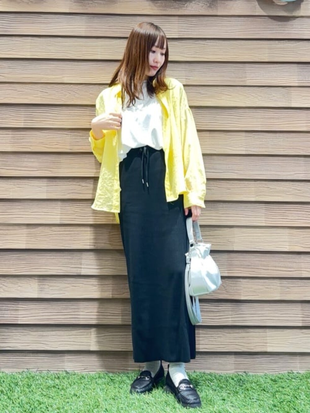 イエロー系のシャツ/ブラウス、ホワイト系のTシャツ/カットソー、ブラック系のスカートを着用したレディースの春コーディネートの1枚目の写真