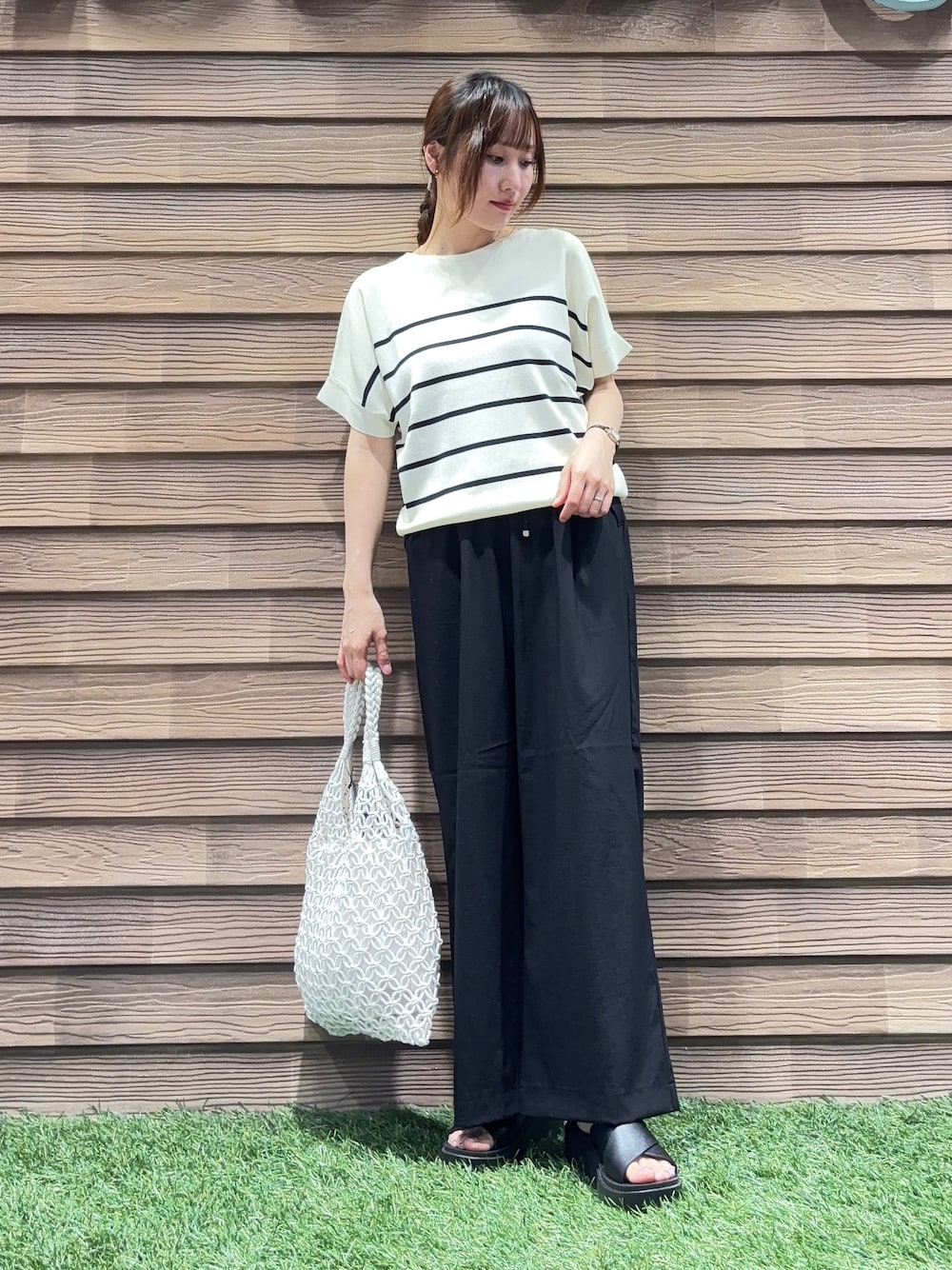ホワイト系のトートバッグ、ブラック系のその他パンツ、ブラック系のサンダルを着用したレディースの春コーディネートの1枚目の写真