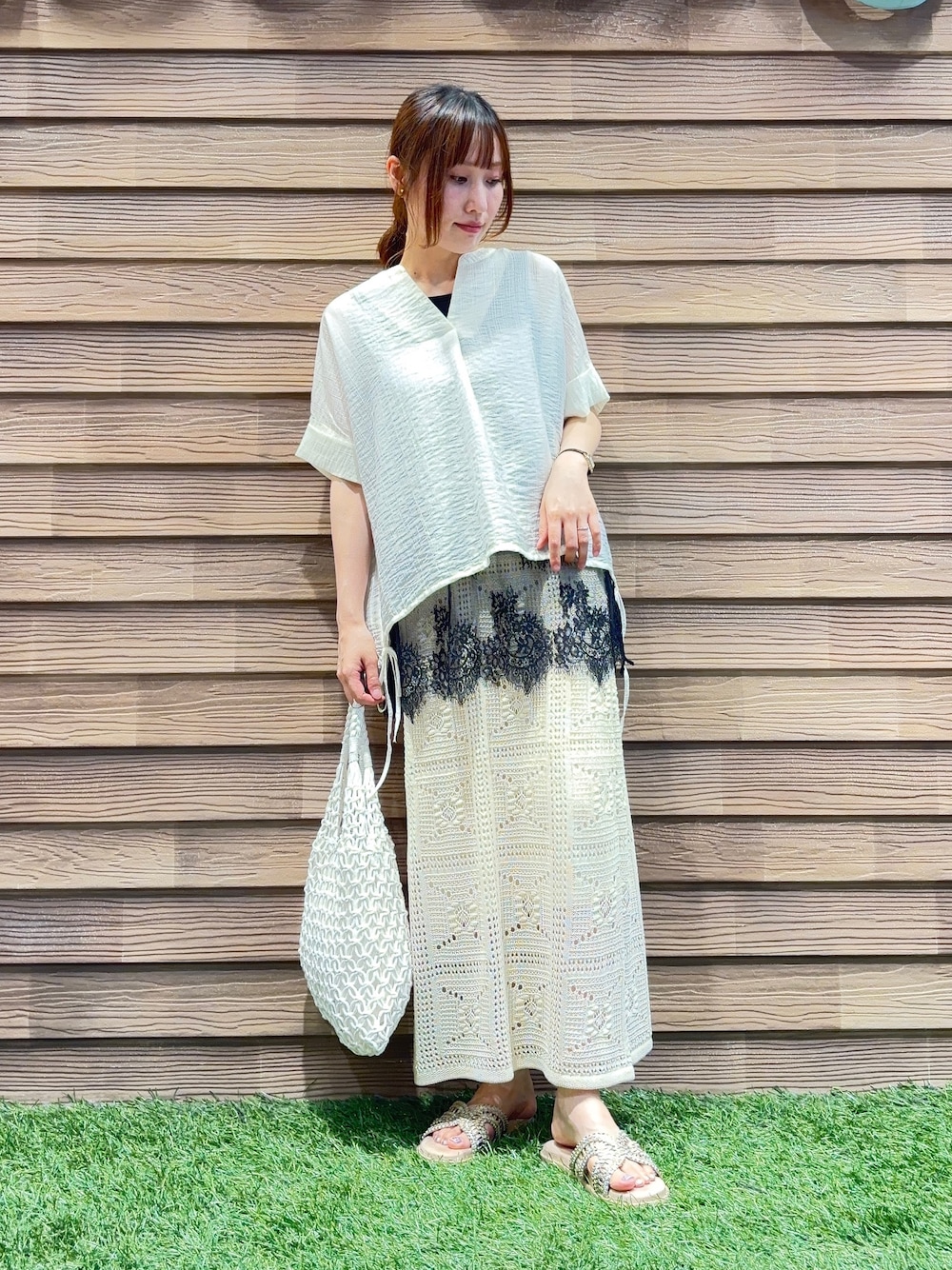 ホワイト系のシャツ/ブラウス、ホワイト系のスカート、ゴールド系のサンダルを着用したレディースの夏コーディネートの1枚目の写真