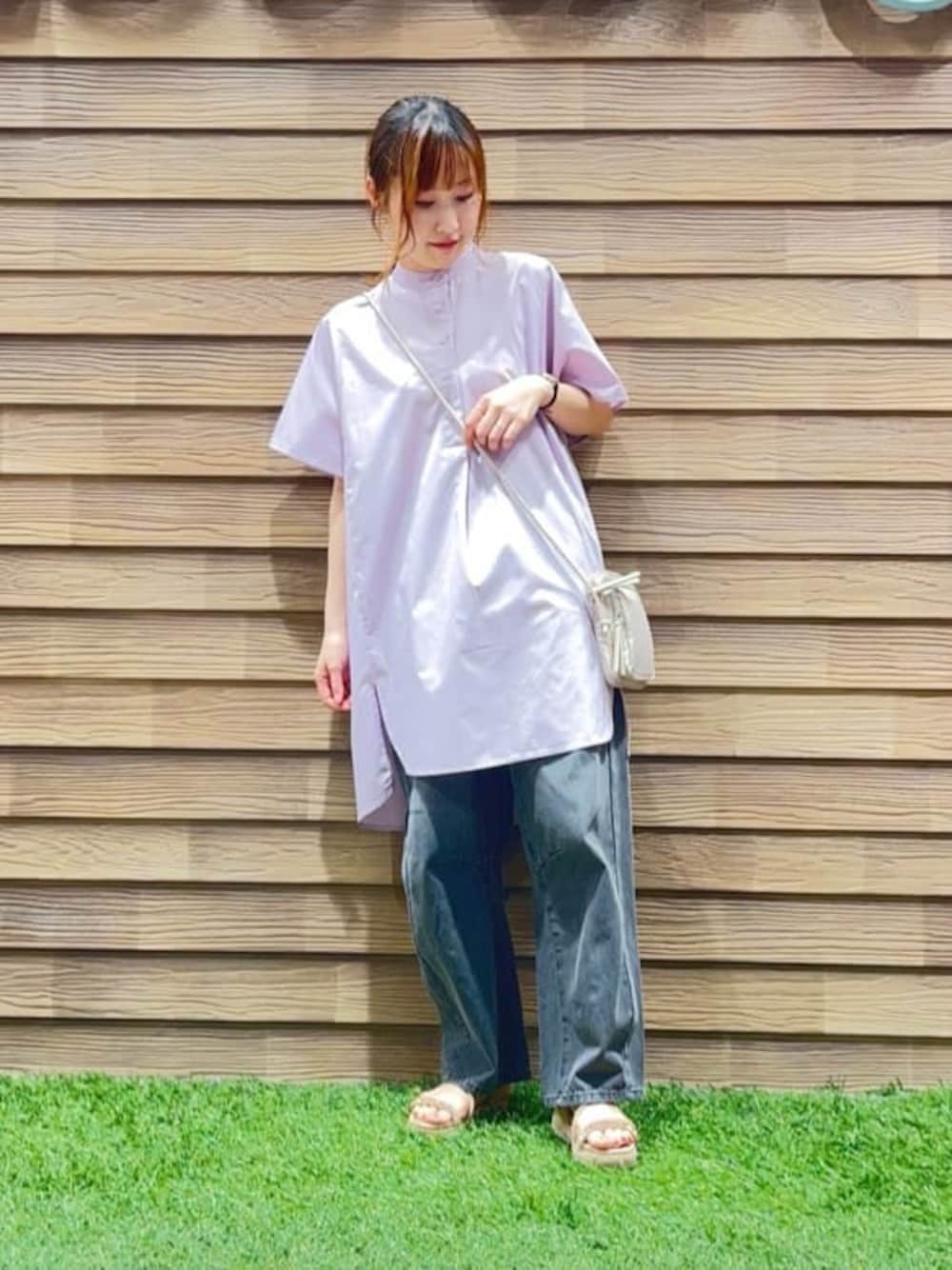 パープル系のチュニック、グレー系のデニムパンツ、ベージュ系のサンダルを着用したレディースの夏コーディネートの1枚目の写真
