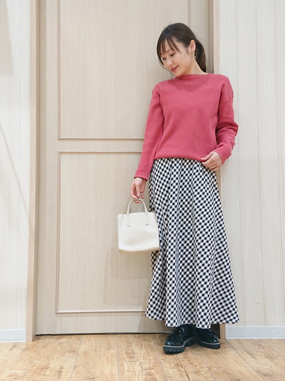 ブルー系のデニムジャケット、ピンク系のニット/セーター、ブラック系のスカートを着用したレディースの春コーディネートの2枚目の写真