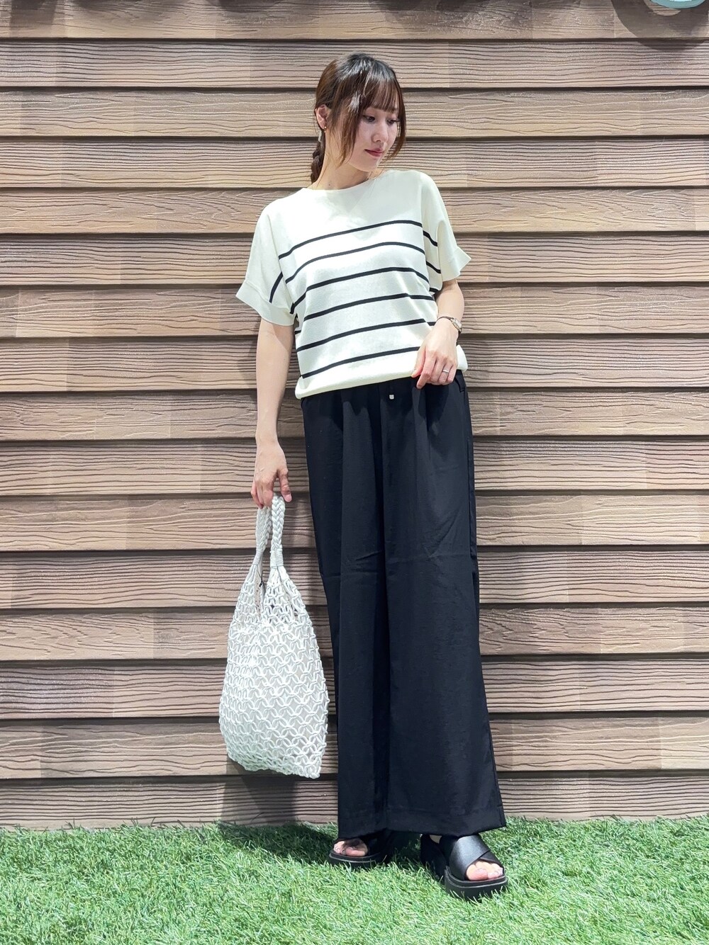 ベージュ系のニット/セーター、ブラック系のその他パンツ、ブラック系のサンダルを着用したレディースの春コーディネートの1枚目の写真