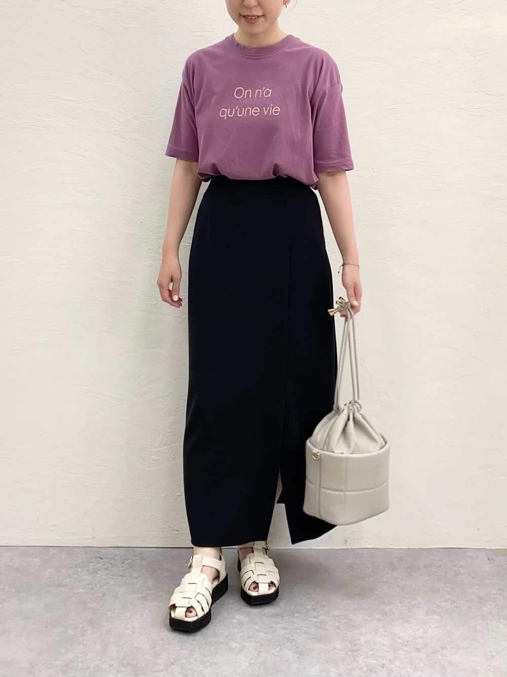 パープル系のTシャツ/カットソー、ブラック系のスカート、ホワイト系のサンダルを着用したレディースの夏コーディネートの1枚目の写真