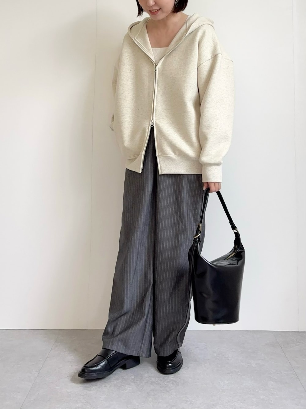 ブラック系のショルダーバッグを着用したレディースの秋コーディネートの1枚目の写真