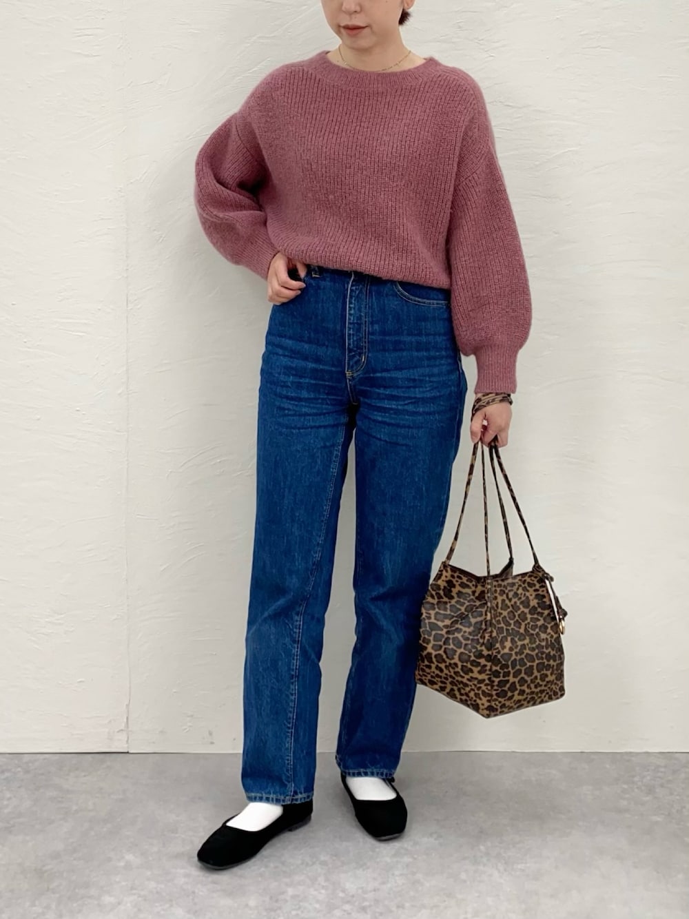 ピンク系のニット/セーター、ブルー系のデニムパンツ、ブラック系のバレエシューズを着用したレディースの冬コーディネートの1枚目の写真