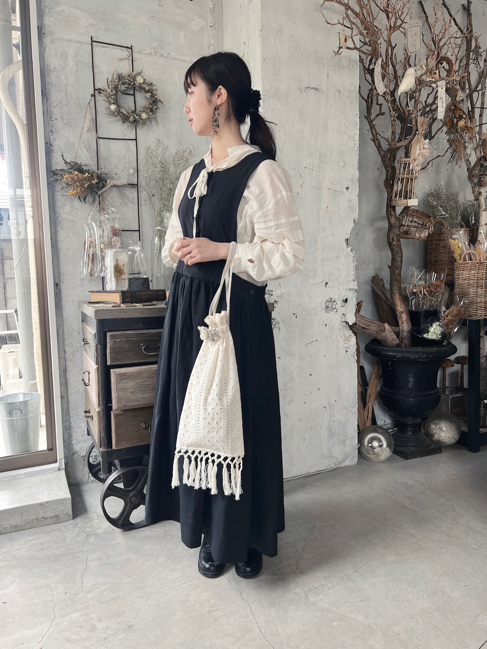 ホワイト系のワンピース、ホワイト系のバッグ、ブラック系のオールインワン・サロペットを着用したレディースの春コーディネートの1枚目の写真