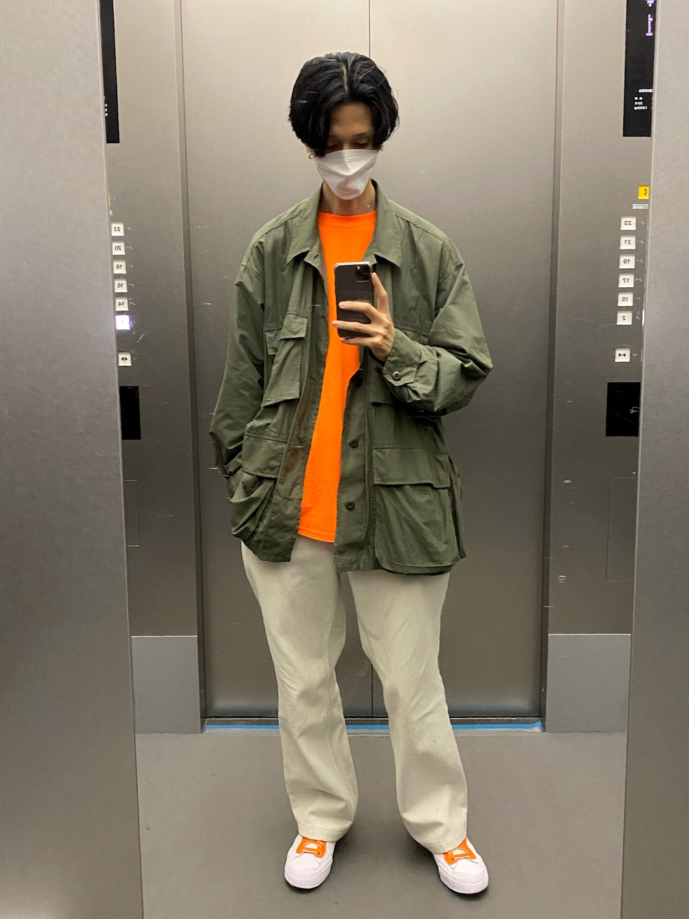 ホワイト系のデニムパンツ、ホワイト系のスニーカー、グリーン系のブルゾンを着用したメンズの夏コーディネートの1枚目の写真