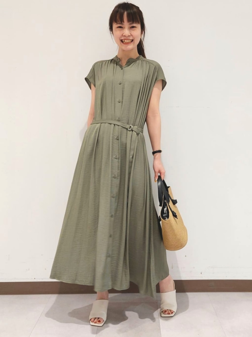 グリーン系のワンピース、ベージュ系のトートバッグを着用したレディースの春コーディネートの1枚目の写真
