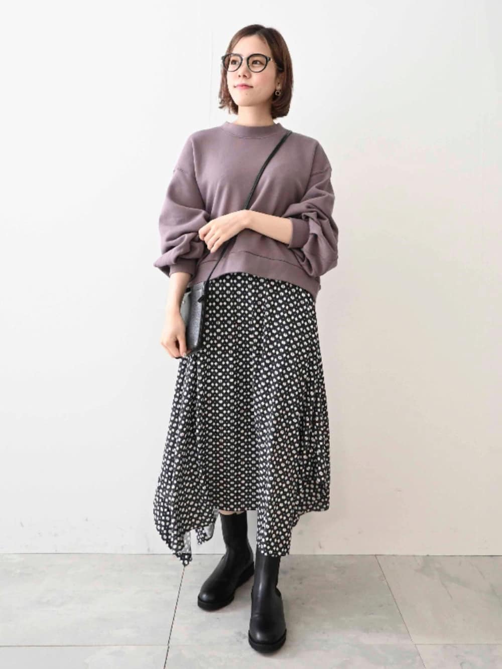 パープル系のスウェット、グレー系のスカート、ブラック系のショルダーバッグを着用したレディースの秋コーディネートの1枚目の写真