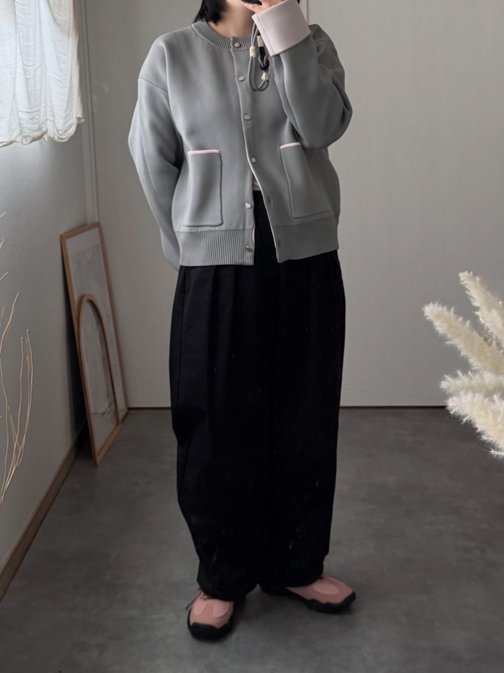 ピンク系のスニーカー、ブラック系のチノパンツ、グレー系のカーディガン/ボレロを着用したレディースの秋コーディネートの1枚目の写真