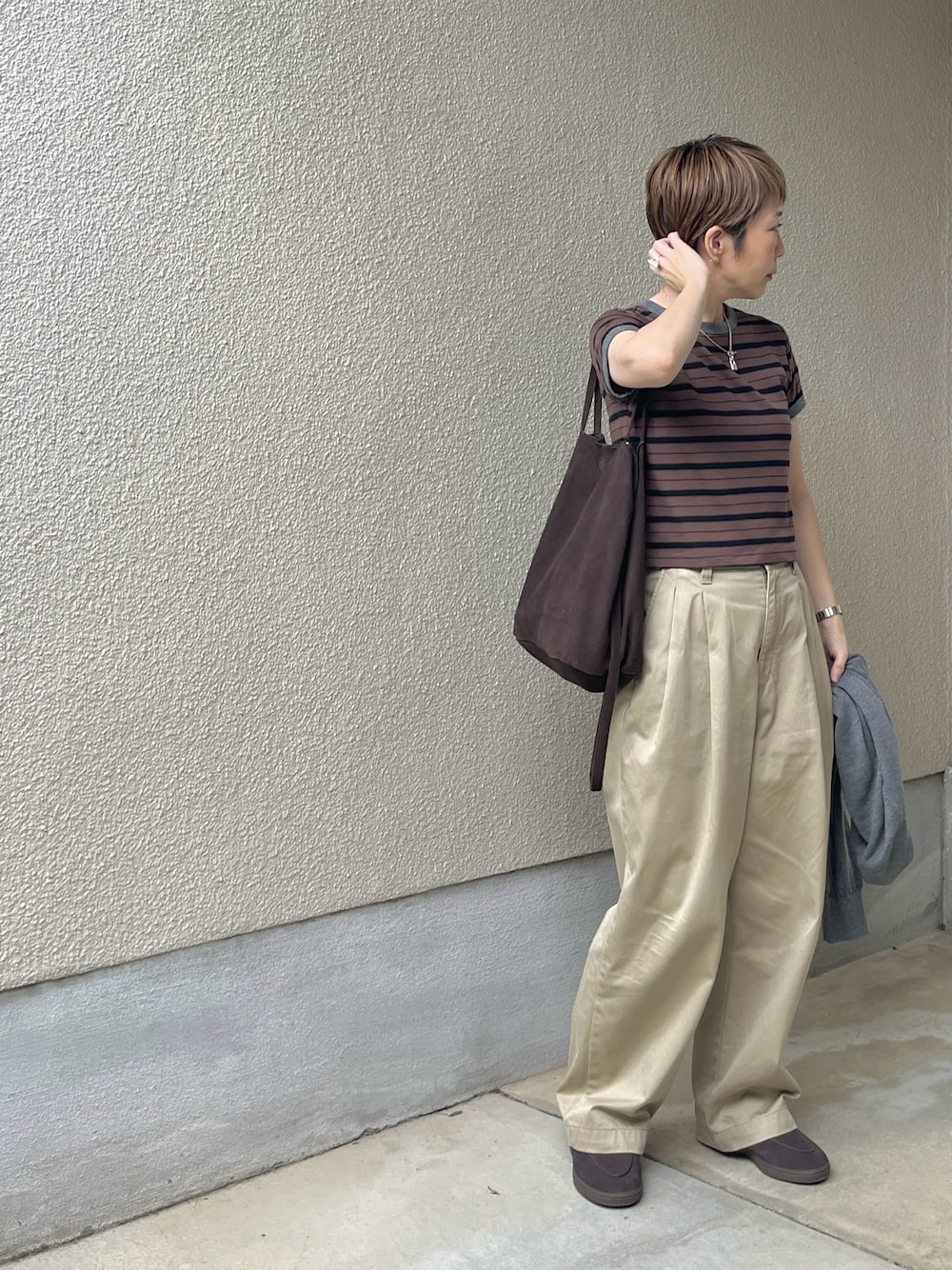 ブラウン系のTシャツ/カットソー、ベージュ系のチノパンツ、ブラウン系のローファーを着用したレディースの秋コーディネートの1枚目の写真